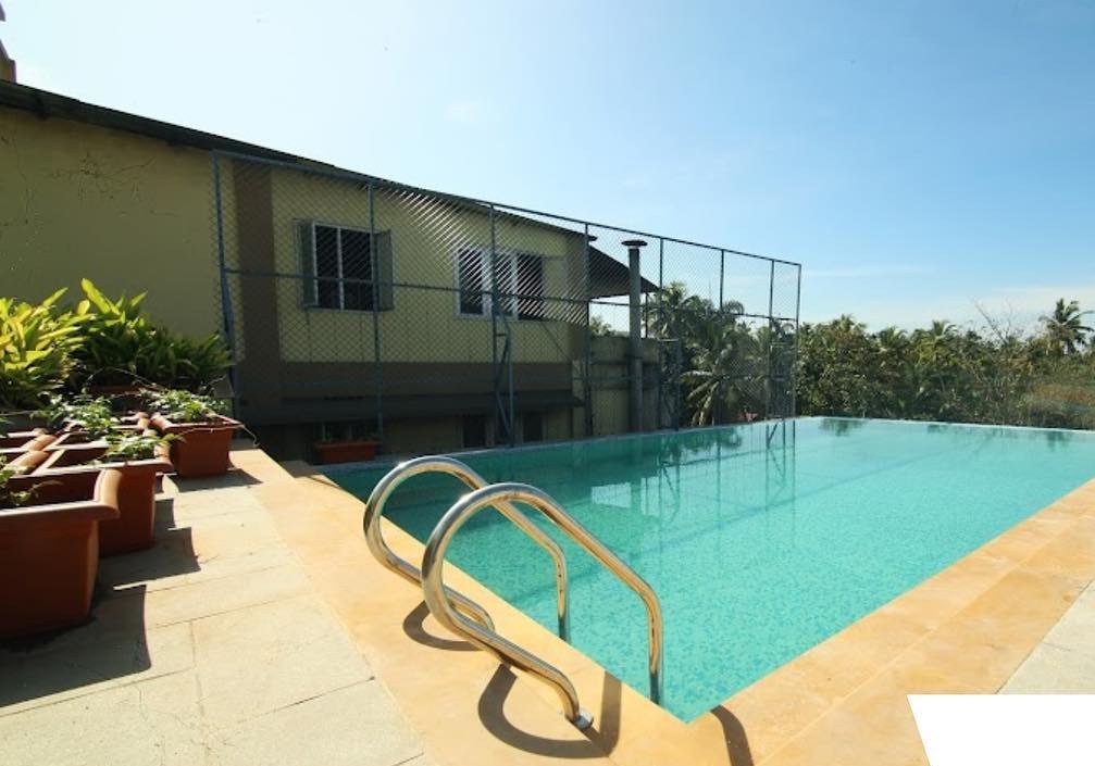 Yash rooftop swimming pool — turquoise water, sandstone deck